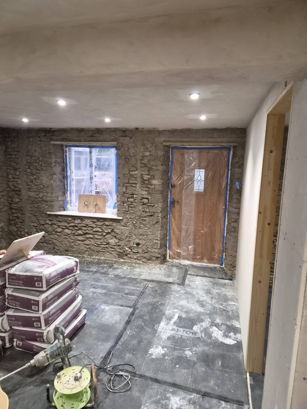 Before: bare rubble stone wall with renovating plaster bags