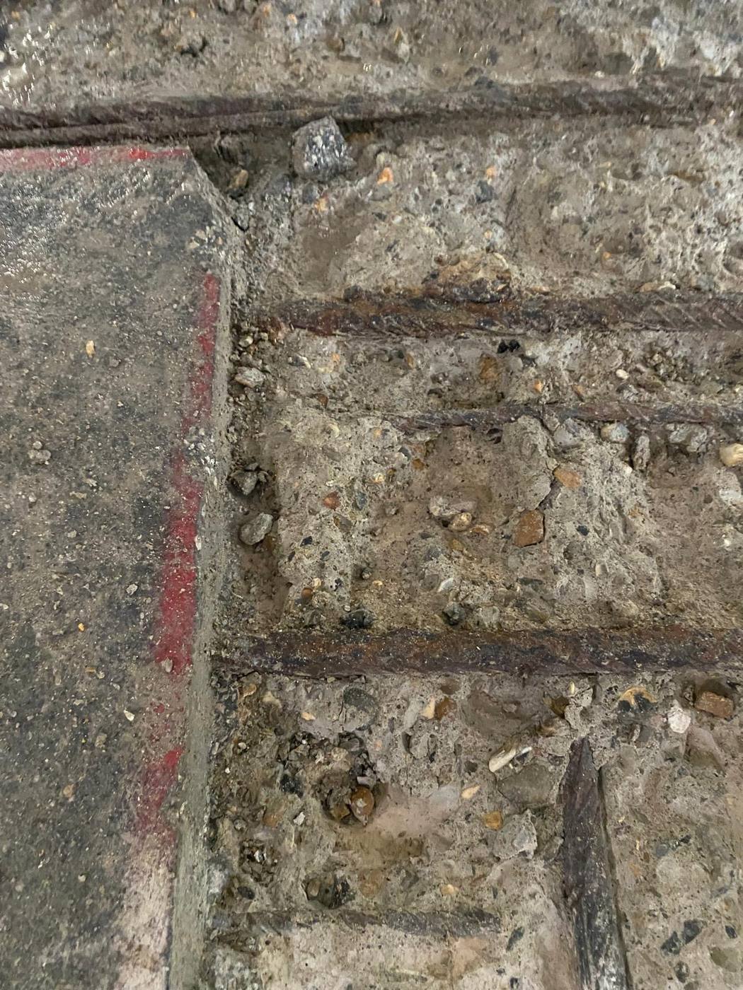 Concrete broken out exposing corroded reinforcement bars