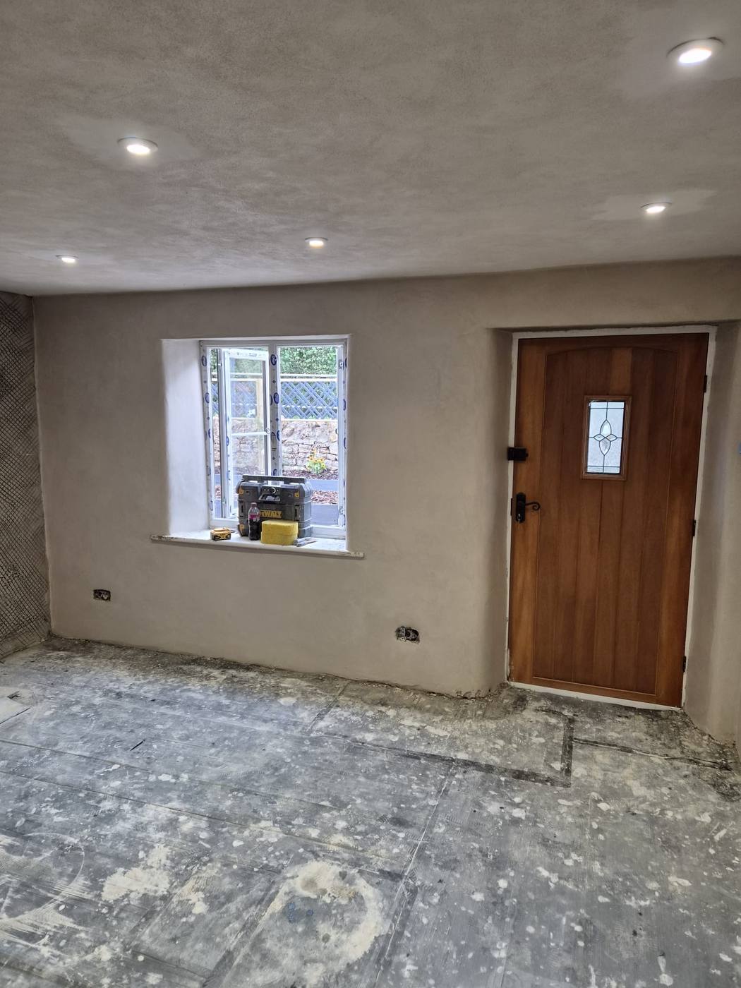 Lime plastered cottage wall with oak door