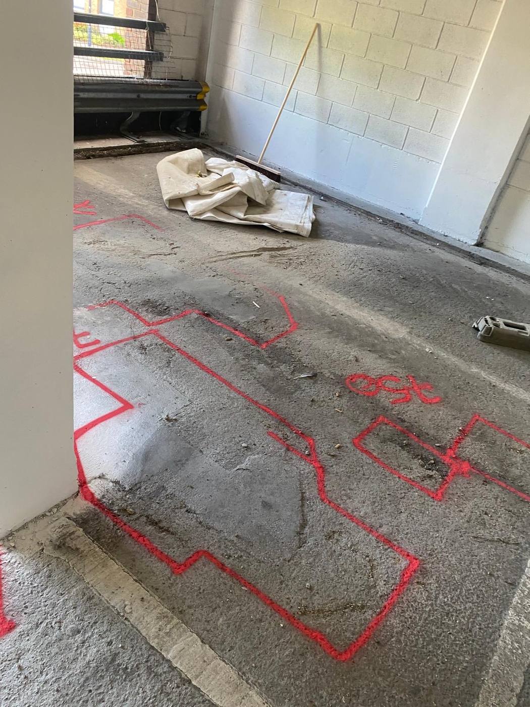 Damaged areas marked out in red on a car park floor
